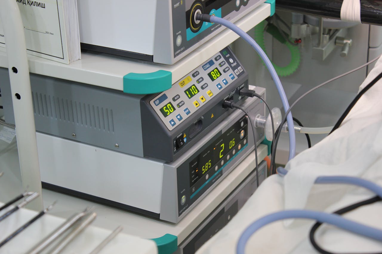 hero-img-02 Close-up view of medical device with digital displays and cables in a hospital setting.