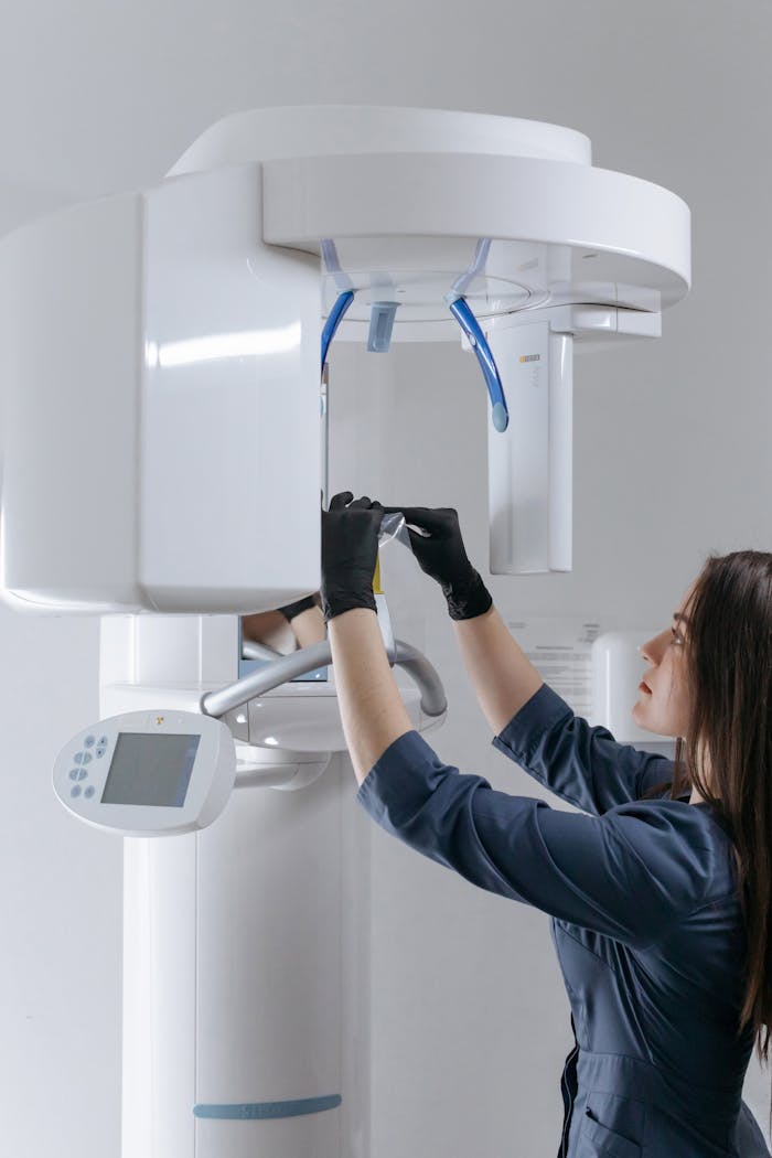 gallery-4 Female dental technician adjusting advanced x-ray machine at clinic.